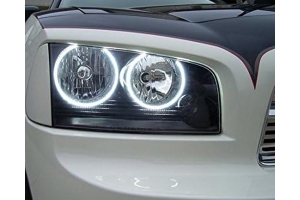 Close-up of a dodge charger headlight showcasing a bright white forward-facing LED halo ring against a dark background.